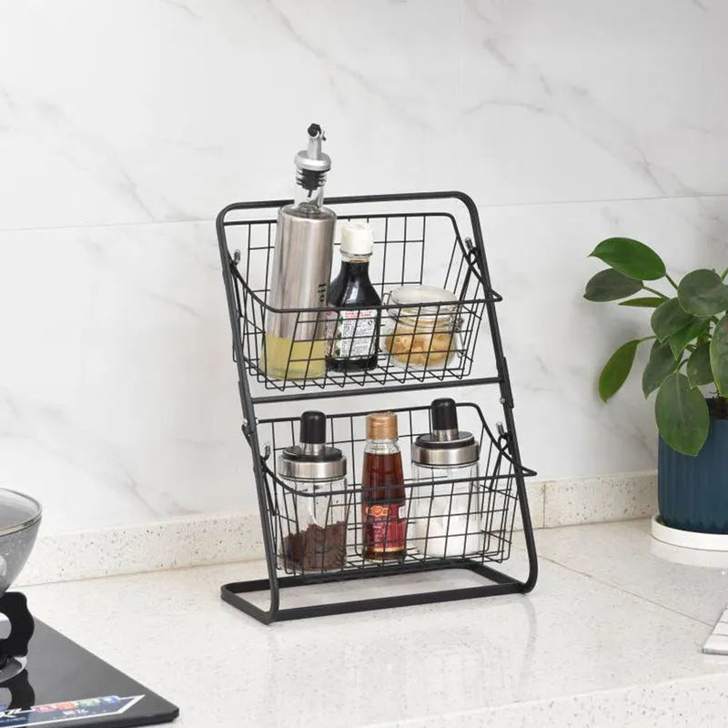 Black two-tier stainless steel kitchen storage rack with fruit and vegetables on countertop