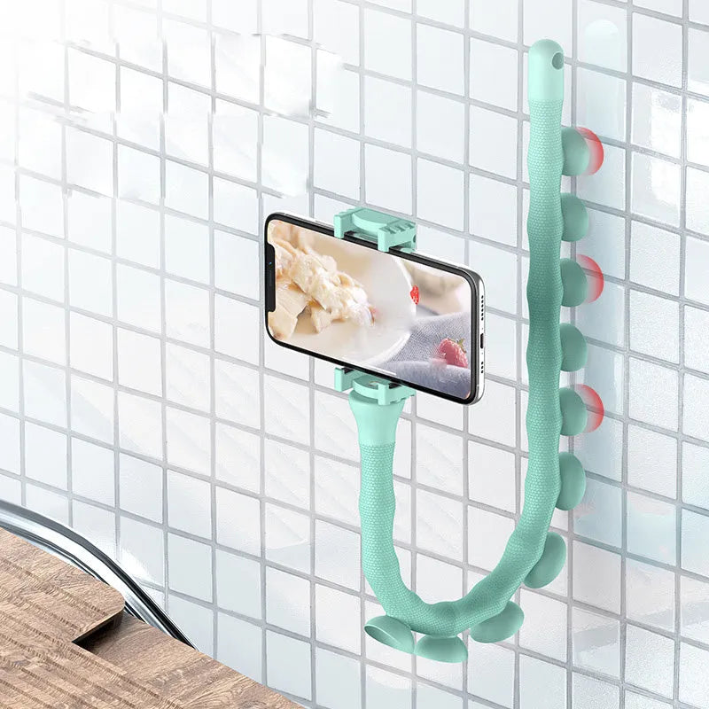 Flexible rubber phone holder with suction cup mounted on a surface showing 360-degree rotation capability