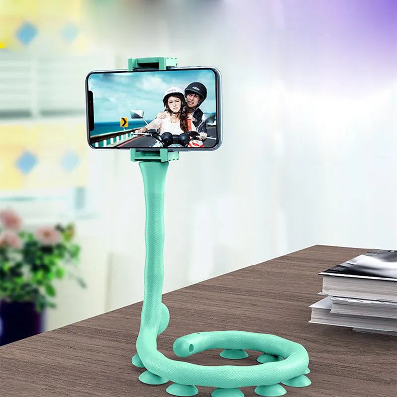 Flexible rubber phone holder with suction cup mounted on a surface showing 360-degree rotation capability