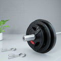 Black rubber covered cast iron barbell weight plates on gym floor