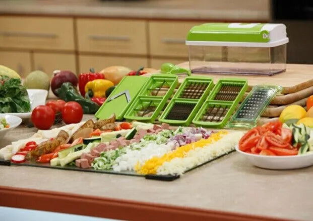 Green 12-piece manual vegetable chopper and food dicer set with stainless steel blades on a kitchen counter.