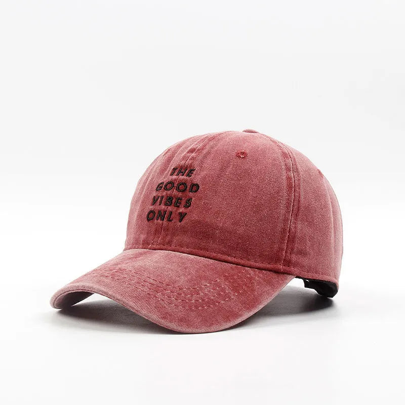 Washed cotton dad hat in bone colour with embroidered THE GOOD VIBES ONLY lettering, adjustable snapback, short curling brim