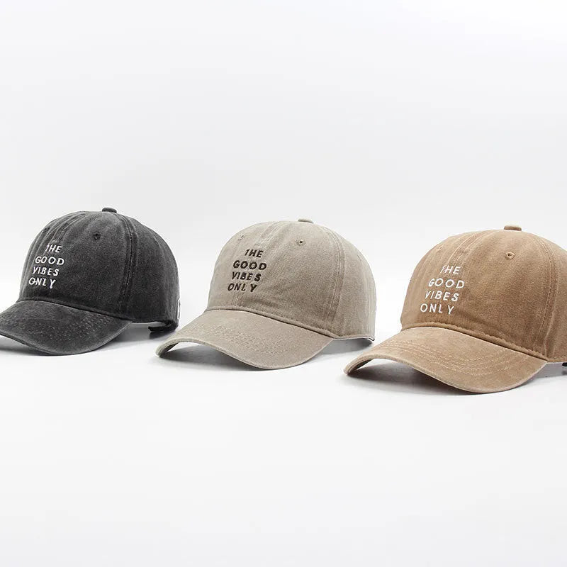 Washed cotton dad hat in bone colour with embroidered THE GOOD VIBES ONLY lettering, adjustable snapback, short curling brim