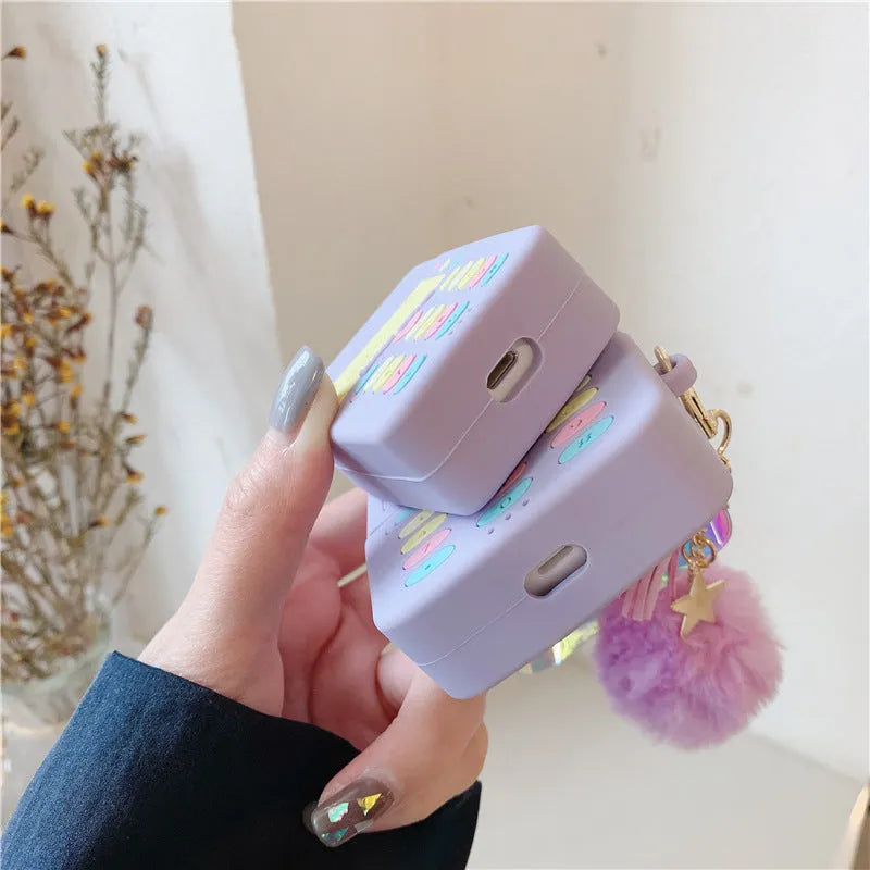 Purple silicone AirPods protective case with clamshell design and attached fur ball pendant