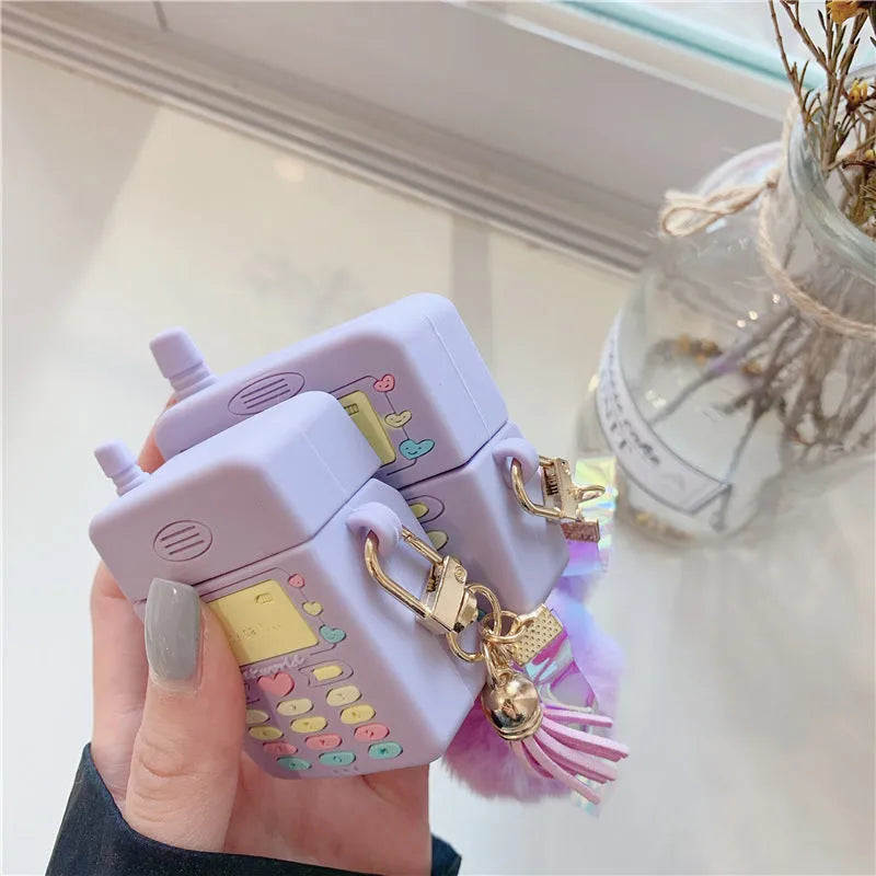 Purple silicone AirPods protective case with clamshell design and attached fur ball pendant