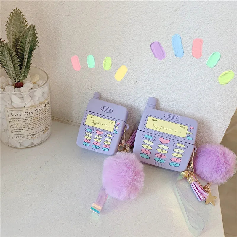 Purple silicone AirPods protective case with clamshell design and attached fur ball pendant