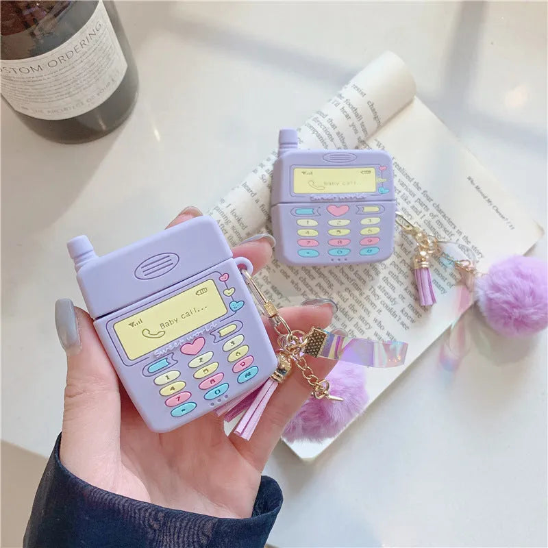 Purple silicone AirPods protective case with clamshell design and attached fur ball pendant