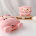 Pink silicone AirPods case with a cartoon pig in a sweater design and a silver keychain hook attached.