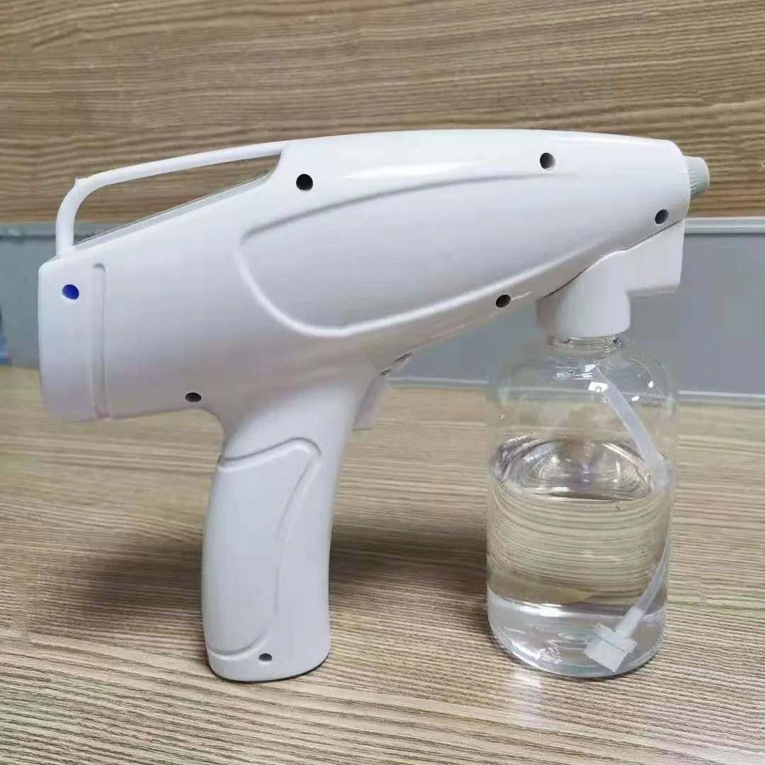 White handheld cordless electric spray disinfection gun with USB charging cable.