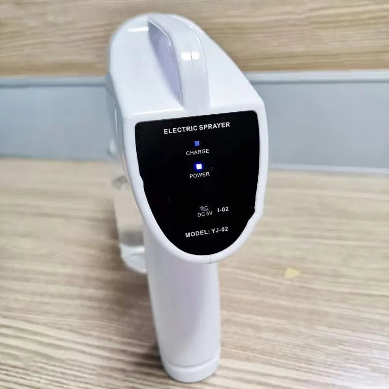 White handheld cordless electric spray disinfection gun with USB charging cable.