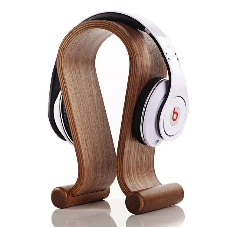 Solid wood earphone display rack in coffee finish on a desk with headphones