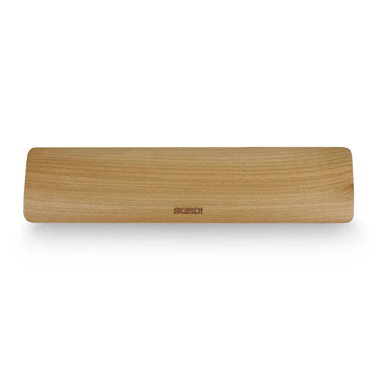 Single-sided wooden keyboard wrist pad in birch wood with machined finish on a desk