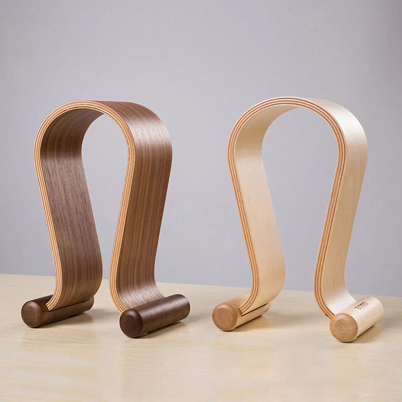 Solid wood earphone display rack in coffee finish on a desk with headphones