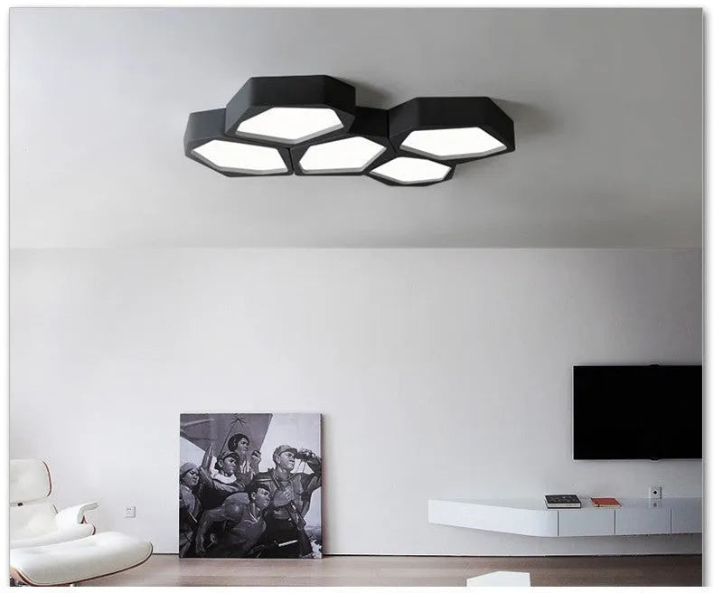 Geometric shaped black iron LED wall light with remote control on a living room wall.