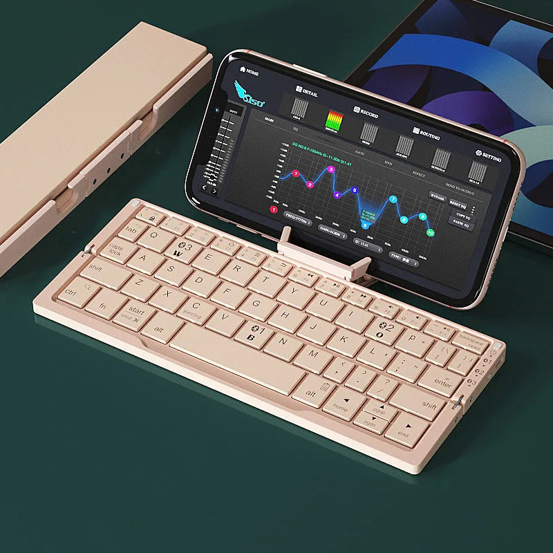 Silver folding Bluetooth keyboard open with phone standing in integrated holder