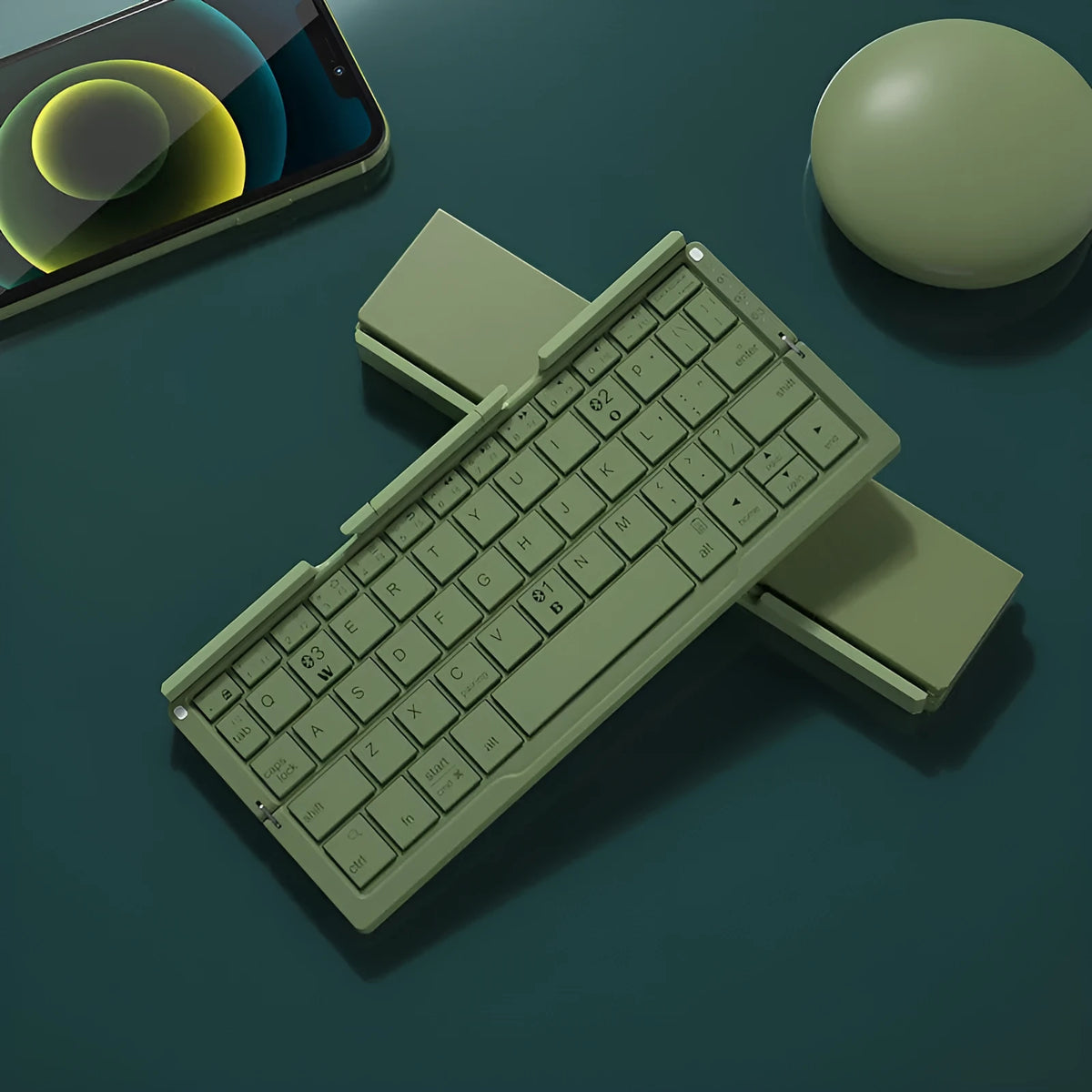 Silver folding Bluetooth keyboard open with phone standing in integrated holder