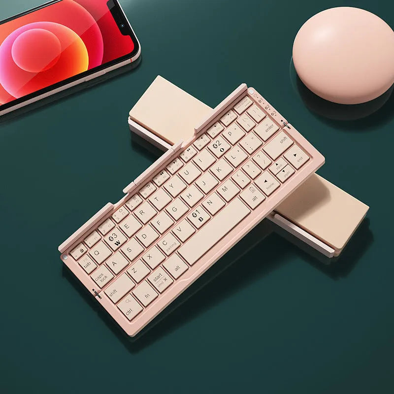 Silver folding Bluetooth keyboard open with phone standing in integrated holder