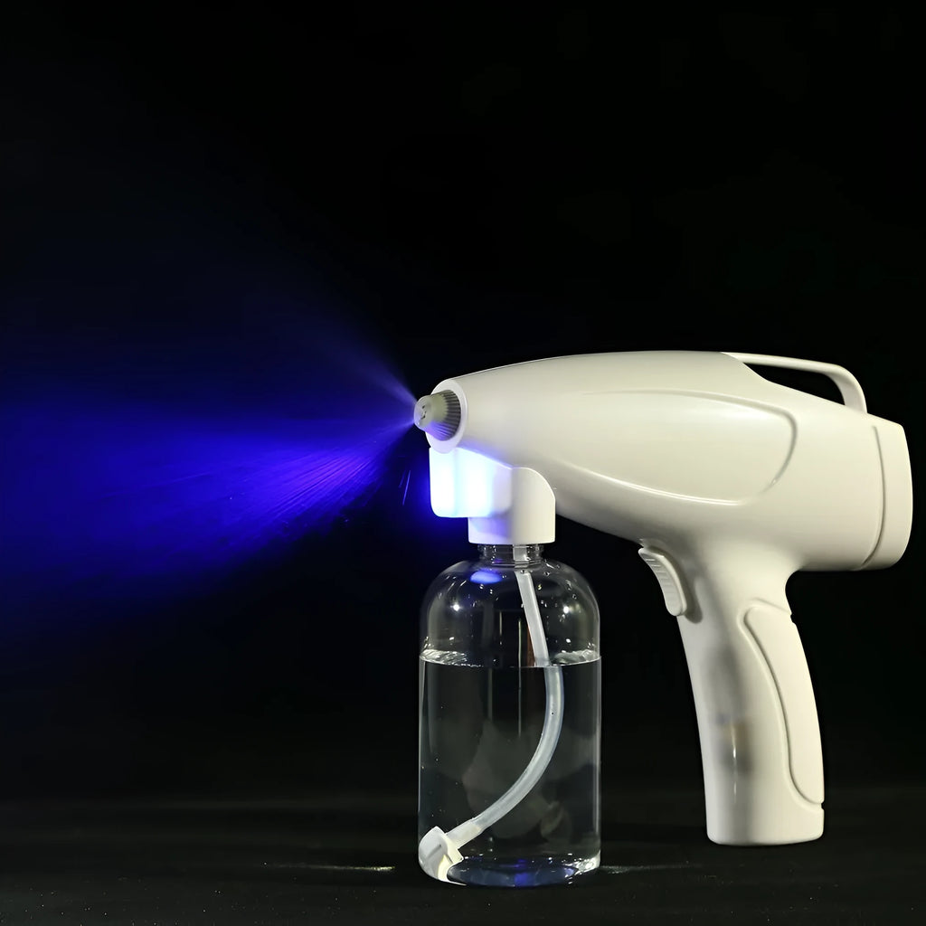 White handheld cordless electric spray disinfection gun with USB charging cable.
