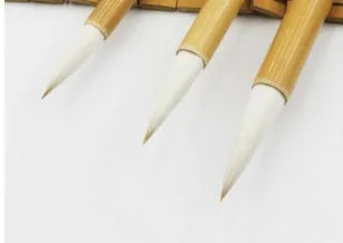 Three Chinese calligraphy brushes with woolen hair bristles and bamboo handles in different sizes