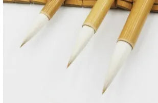 Three Chinese calligraphy brushes with woolen hair bristles and bamboo handles in different sizes