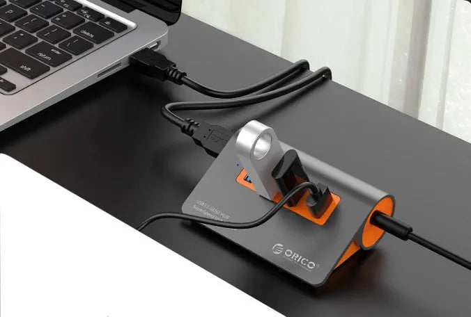 Dark grey and orange aluminium USB C hub with four USB 3.1 ports and a separate cable.