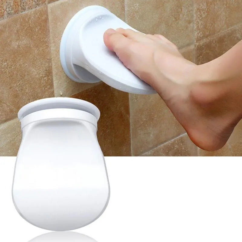 White plastic shower foot rest with suction cups, used as a step for washing feet or shaving legs in the bath or shower.