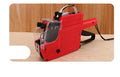 Manual price coding machine in blue, red, or yellow with label paper and ink roller for shop labelling.