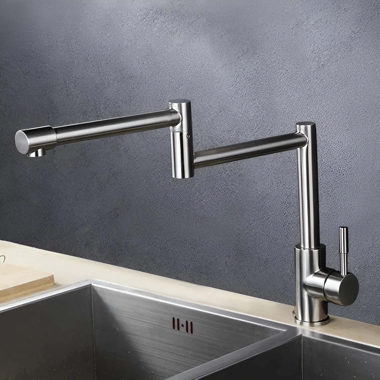Silver stainless steel kitchen tap with rotating spout showing 360-degree movement capability