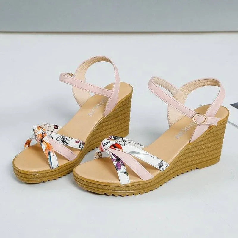 Women's pink wedge heel sandals with fish mouth design and a single ankle buckle.