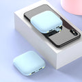 Compact black mini power bank with 20000mAh capacity and LED flashlight on a table.