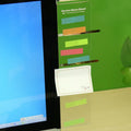 Transparent acrylic computer monitor side pane 28 x 7.8 cm holding a note on the side of a monitor