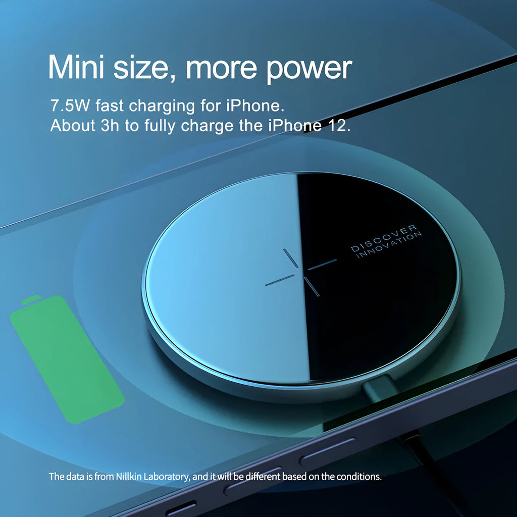 Black MagSlim magnetic wireless charging pad on a table next to a mobile phone.