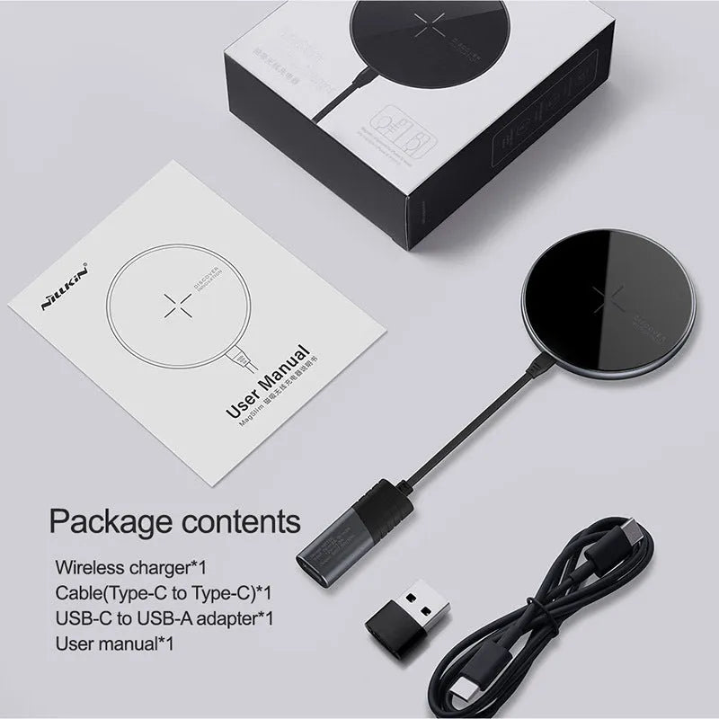 Black MagSlim magnetic wireless charging pad on a table next to a mobile phone.