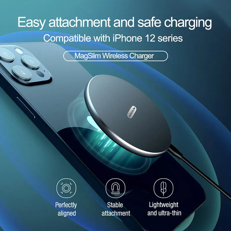 Black MagSlim magnetic wireless charging pad on a table next to a mobile phone.