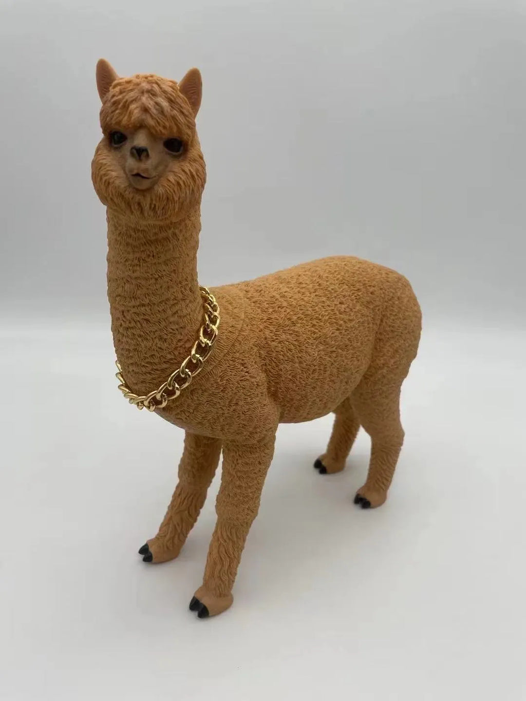 Portable Bluetooth speaker shaped like a brown alpaca with wood base, FM radio, and lanyard