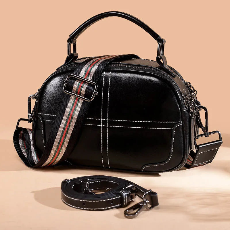Round leather handbag with double soft handles and zip closure in wine red colour