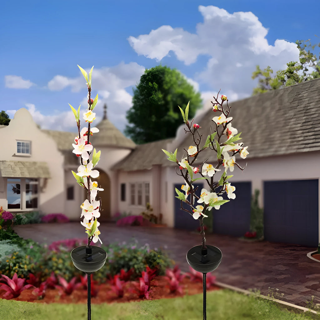 Solar-powered outdoor garden stake light with cherry blossom string LEDs and ground spike.