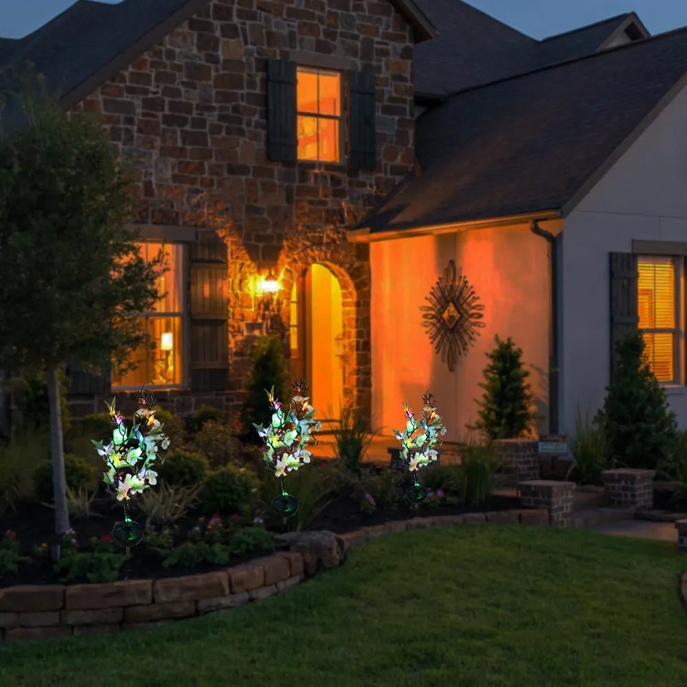 Solar-powered outdoor garden stake light with cherry blossom string LEDs and ground spike.