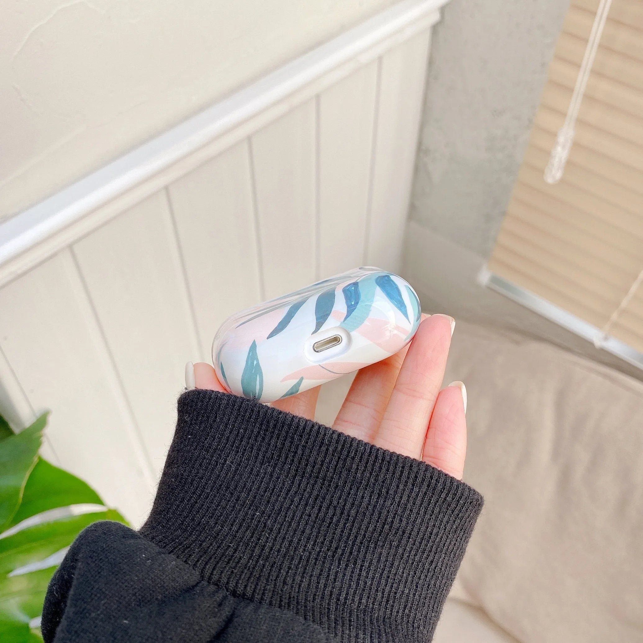 Blue TPU AirPods case with a painted tropical banana leaf design.
