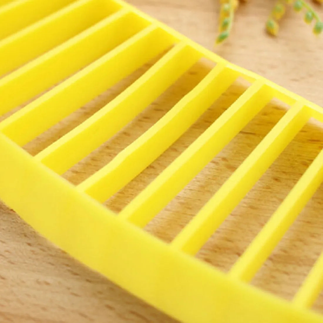Yellow banana cutter food grade PP plastic kitchen tool approximately 25 cm long on a white background
