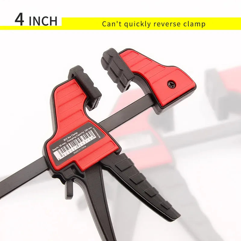 Black plastic woodworking clamp with rubber grip showing quick adjustment key and clamping mechanism