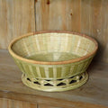 Handmade woven natural bamboo storage basket shown in a household setting.