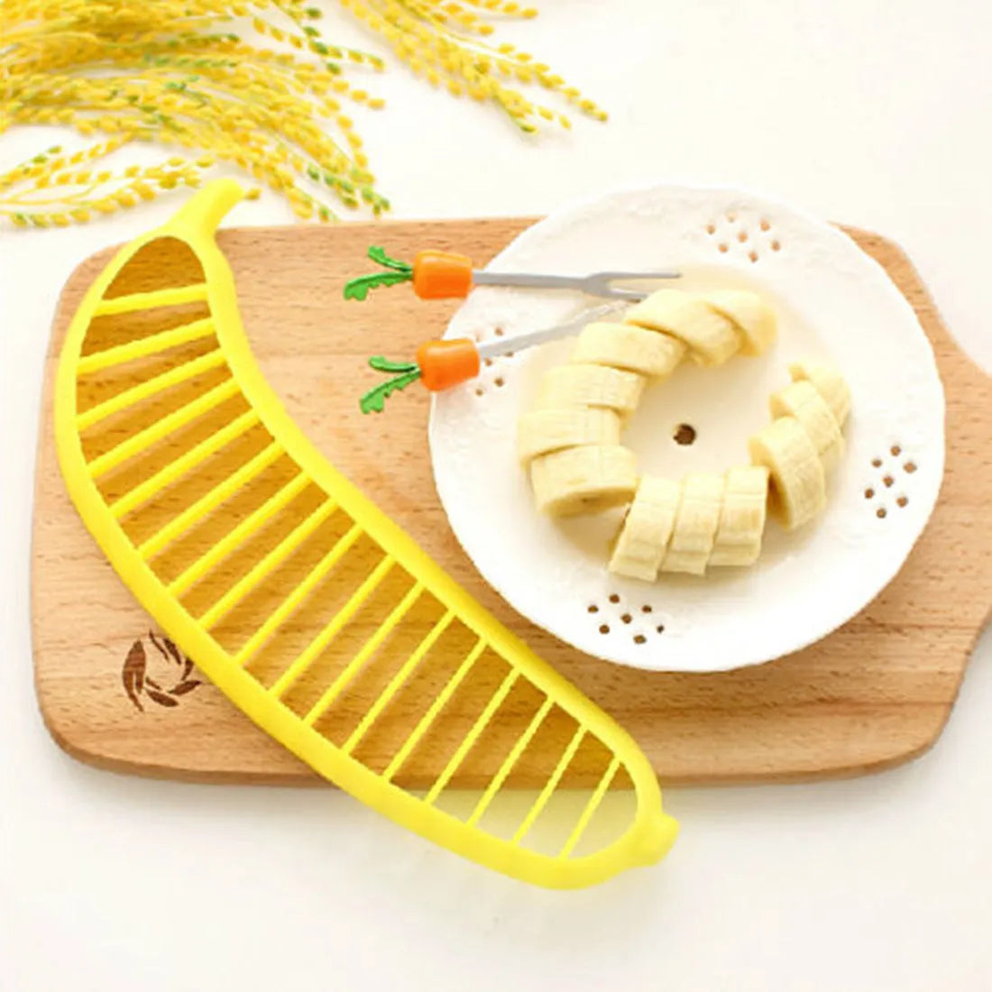 Yellow banana cutter food grade PP plastic kitchen tool approximately 25 cm long on a white background