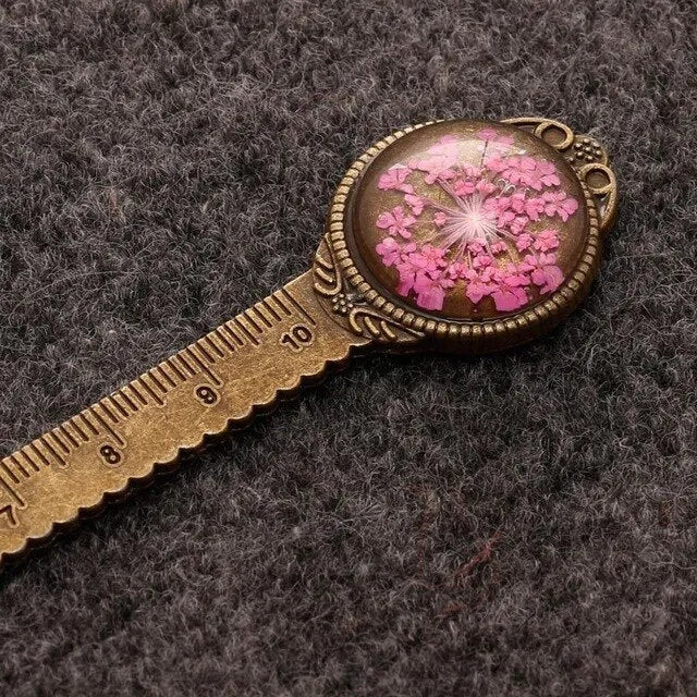Handmade dried flower bookmark ruler with gypsophila, lace flowers, and clover, 12cm long on a book page.