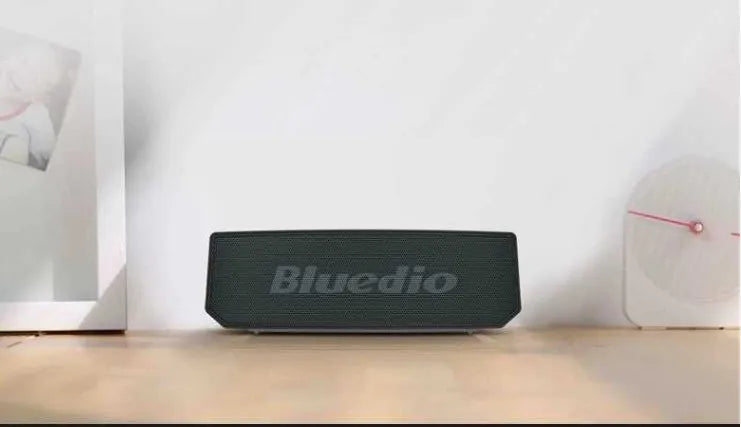 Black Bs-6 Bluetooth smart speaker on a desk showing its compact rectangular form.