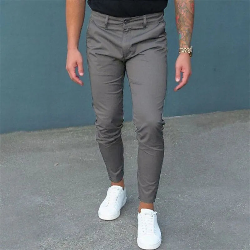 Men's pure color tight trousers in black, side view, showing mid waist and micro-elastic polyester fabric.