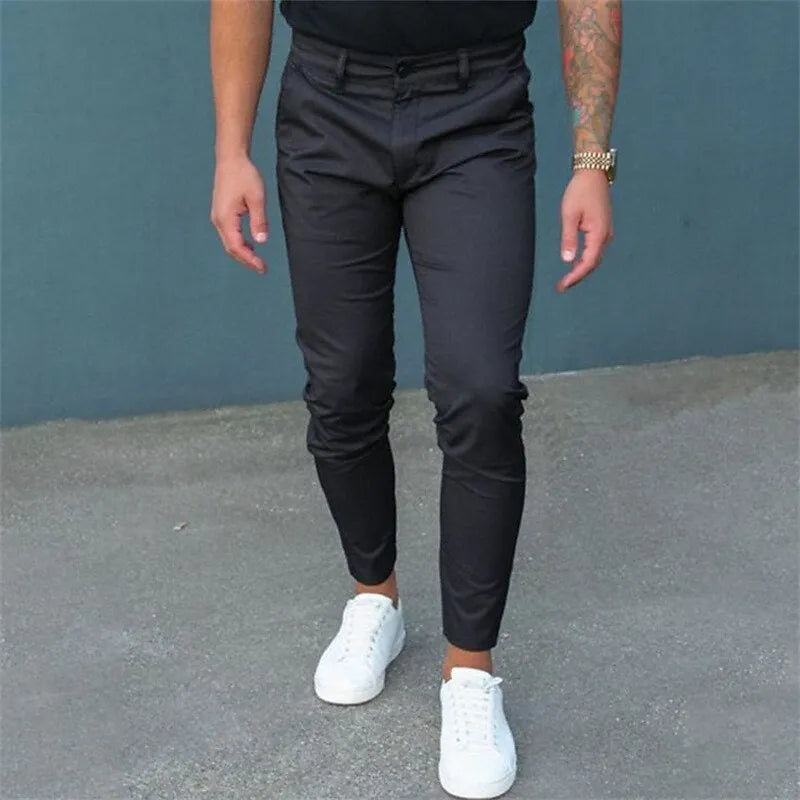Men's pure color tight trousers in black, side view, showing mid waist and micro-elastic polyester fabric.
