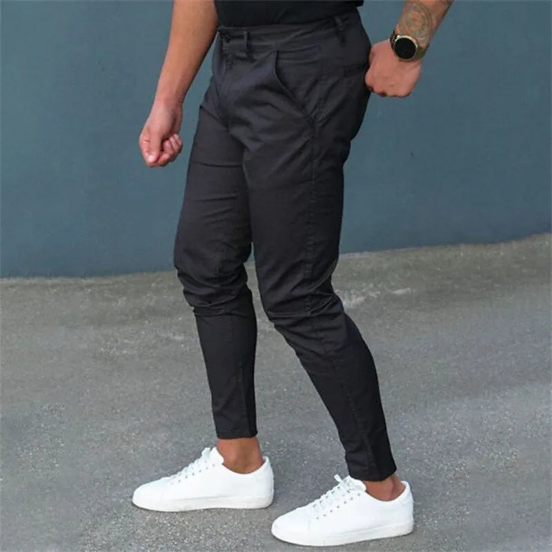 Men's pure color tight trousers in black, side view, showing mid waist and micro-elastic polyester fabric.