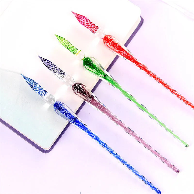 Set of four luminous glass crystal dip pens in assorted colours on a white background