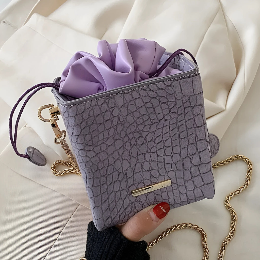 Women's chain messenger bag in bucket style with zip opening and adjustable shoulder strap